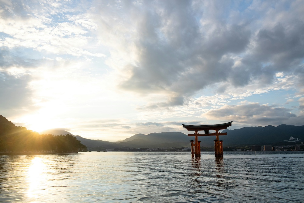 Portail torii traditionnel japonais dans l'eau au coucher du soleil